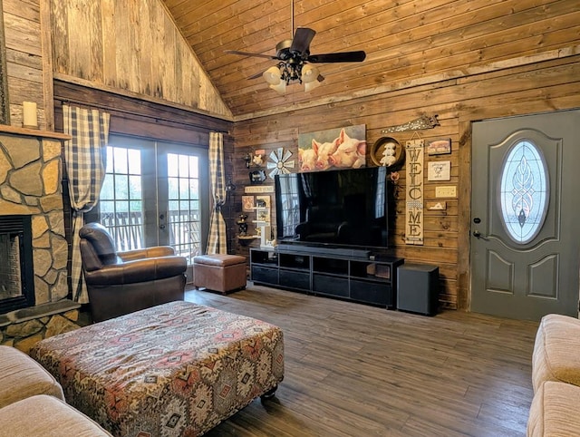 living room featuring a fireplace, ceiling fan, wooden walls, wood finished floors, and wooden ceiling