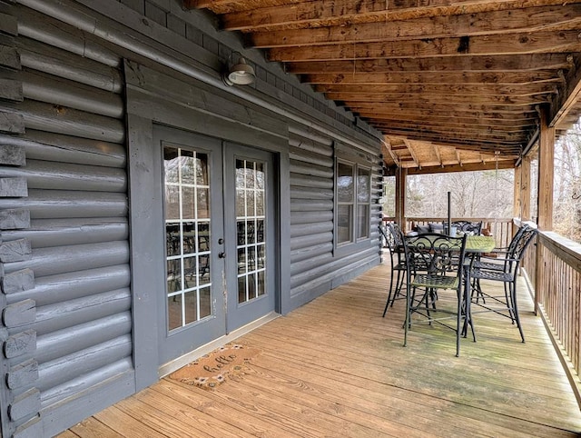 wooden terrace with outdoor dining space and french doors