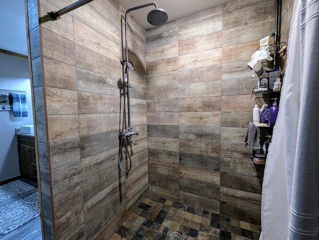 bathroom with a tile shower and vanity