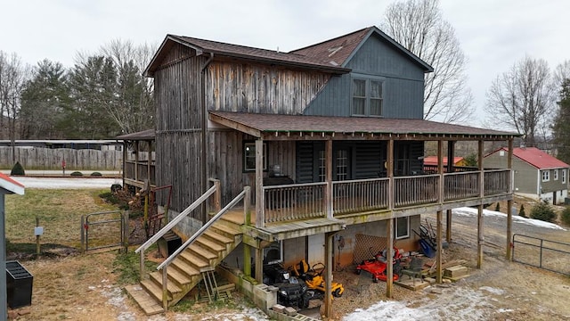 exterior space with stairs, roof with shingles, and fence