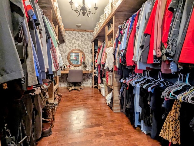 walk in closet featuring an inviting chandelier and wood finished floors