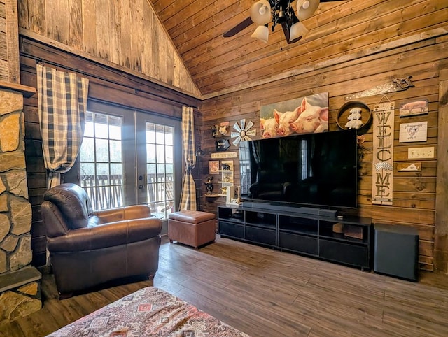 living area with wood ceiling, ceiling fan, wooden walls, wood finished floors, and high vaulted ceiling