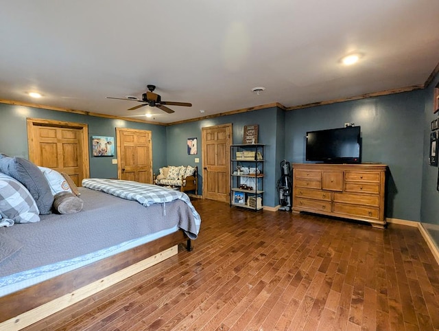 bedroom featuring a ceiling fan, crown molding, baseboards, and wood finished floors