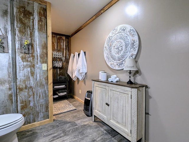 bathroom with wood finished floors, toilet, and baseboards