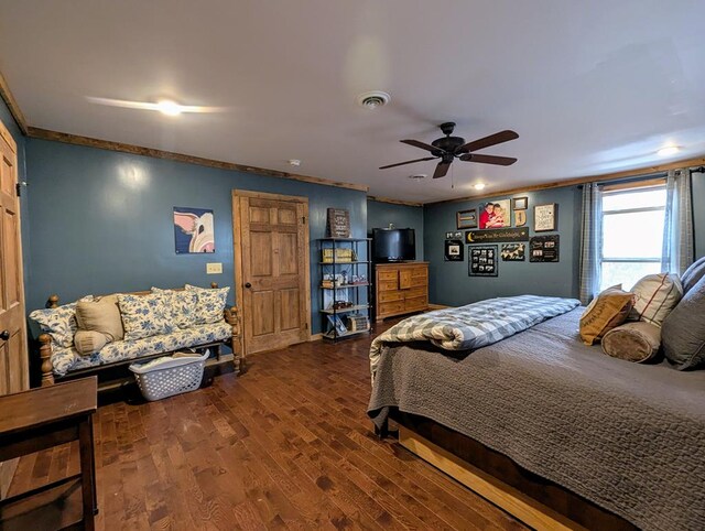 bedroom featuring ceiling fan, visible vents, crown molding, and wood finished floors