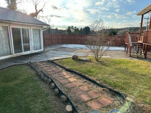 view of yard featuring a wooden deck and a patio