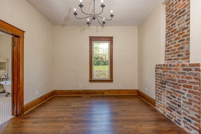 unfurnished room with baseboards, an inviting chandelier, and wood finished floors