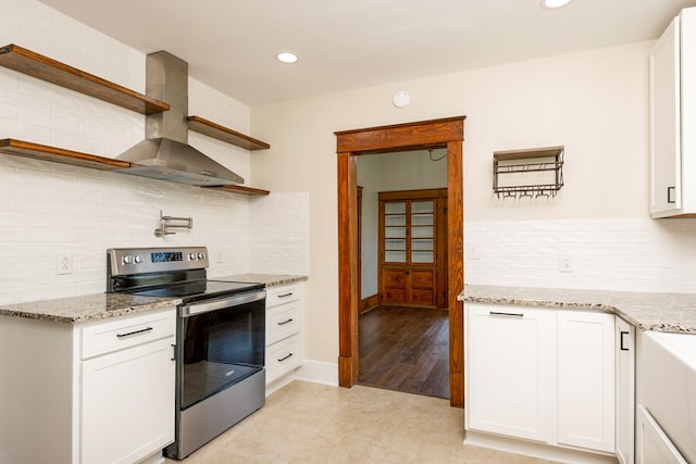 kitchen featuring electric range, light stone countertops, wall chimney exhaust hood, and open shelves