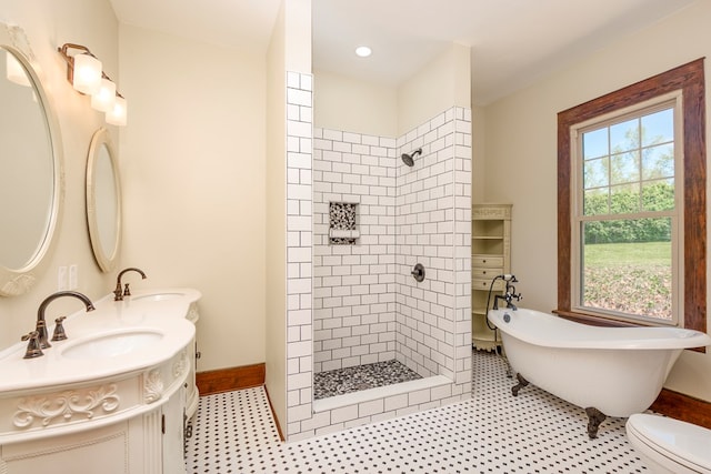 bathroom with a sink, a soaking tub, double vanity, and a tile shower