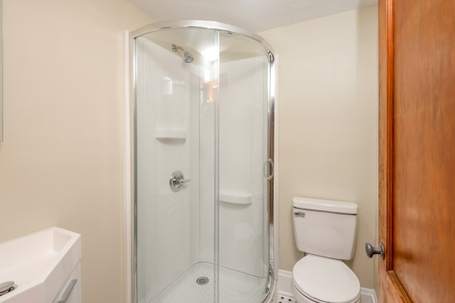 bathroom featuring a stall shower and toilet