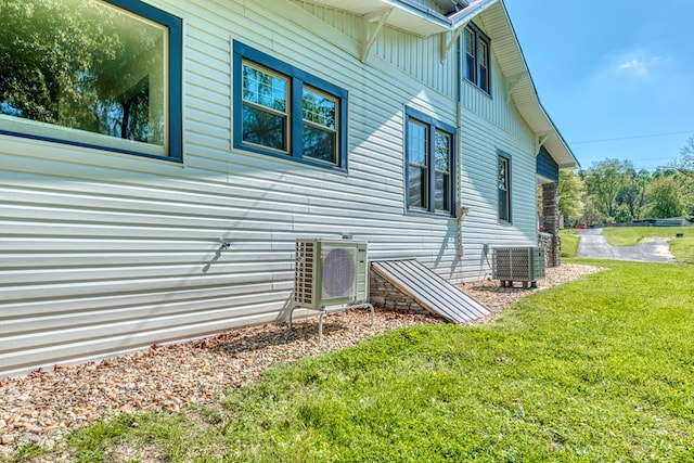 view of home's exterior with ac unit, a yard, and central AC