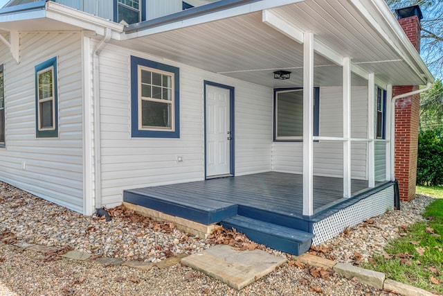 property entrance with covered porch and a chimney