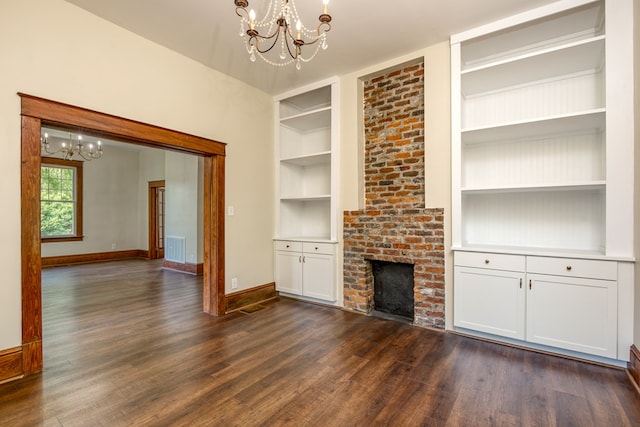 unfurnished living room with built in features, baseboards, dark wood-type flooring, and a chandelier