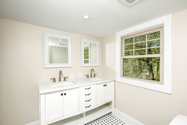 bathroom featuring a sink, baseboards, and a wealth of natural light