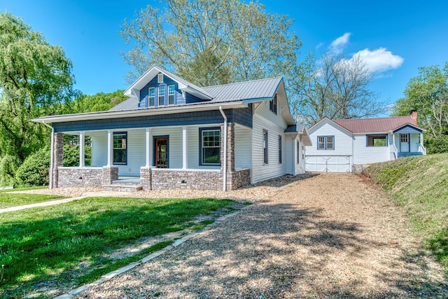 bungalow-style house featuring stone siding, covered porch, and a front yard