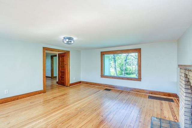 unfurnished living room with visible vents, baseboards, and hardwood / wood-style flooring