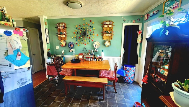 dining space with a textured ceiling and crown molding