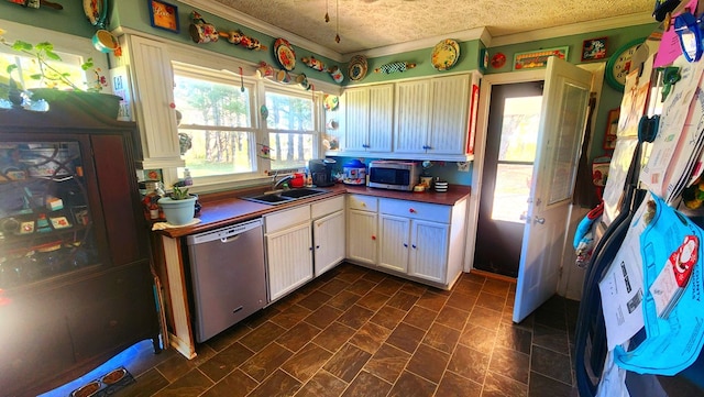 kitchen featuring stainless steel appliances, a sink, a wealth of natural light, and crown molding
