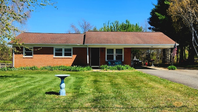 single story home featuring brick siding, a front lawn, driveway, and an attached carport