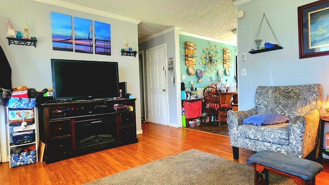 living room with crown molding and wood finished floors