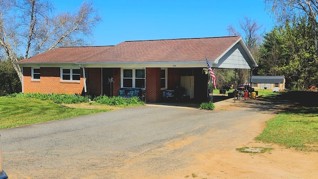 ranch-style house featuring brick siding, aphalt driveway, and a front yard