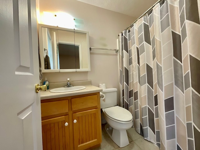 bathroom featuring toilet, a shower with curtain, vanity, and tile patterned floors