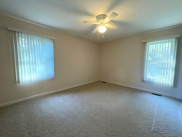 spare room with ceiling fan, baseboards, carpet flooring, and visible vents