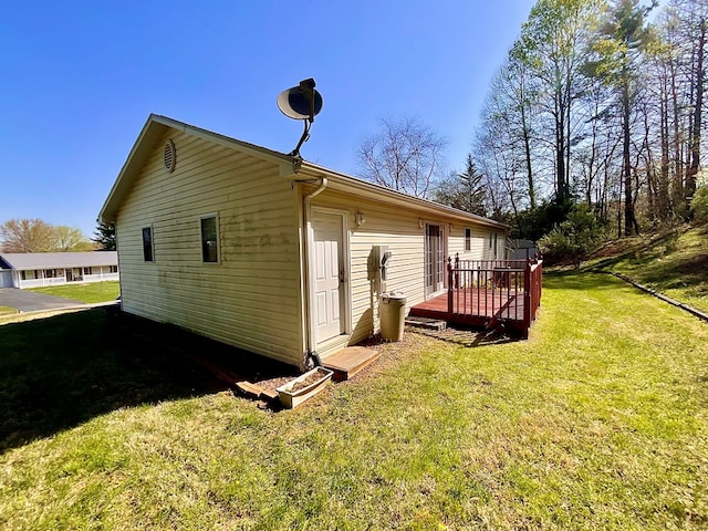 rear view of house featuring a lawn and a deck