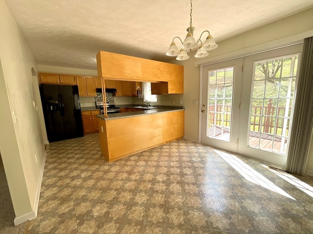 kitchen with black fridge with ice dispenser, stainless steel electric range, an inviting chandelier, baseboards, and a peninsula