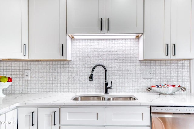 kitchen featuring dishwasher, a sink, tasteful backsplash, and white cabinets