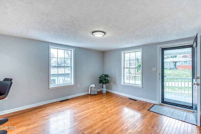 entrance foyer featuring hardwood / wood-style flooring, baseboards, and a textured ceiling