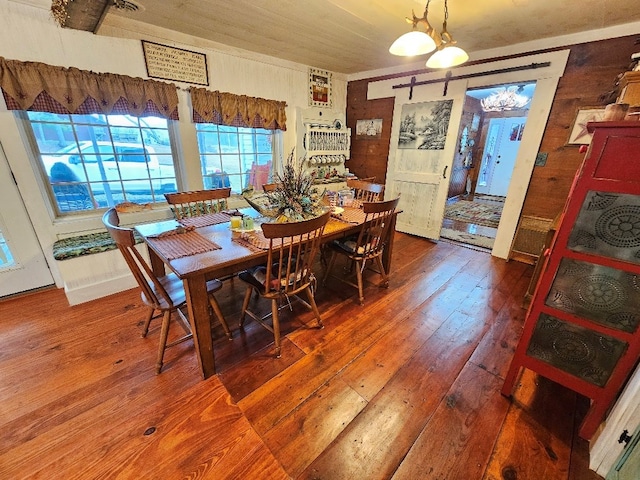 dining area with hardwood / wood-style floors and wooden walls