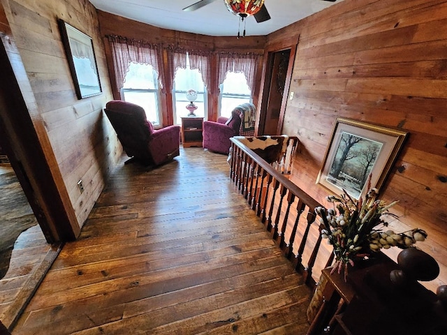 corridor with wood walls and hardwood / wood-style flooring