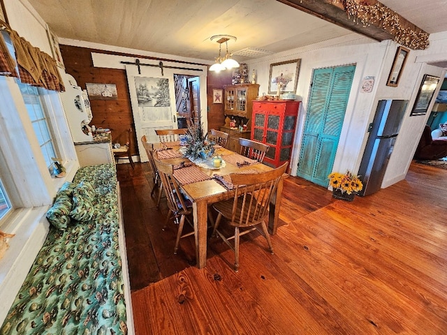 dining space featuring hardwood / wood-style floors and wooden walls