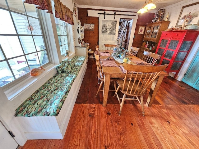 dining space featuring wood walls and wood finished floors