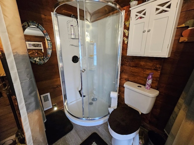 full bath with toilet, a stall shower, visible vents, and wood walls