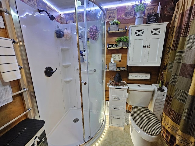 full bath featuring tile patterned flooring, a shower stall, and toilet