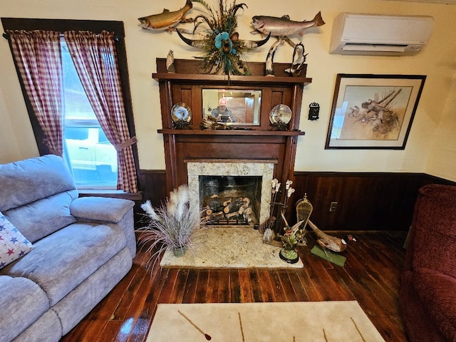 living area with a wall unit AC, a wainscoted wall, wooden walls, and a high end fireplace