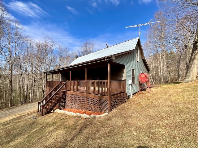 view of front of home featuring metal roof and a front yard