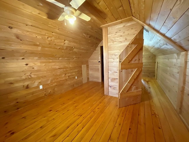 additional living space with a ceiling fan, light wood finished floors, lofted ceiling, wood ceiling, and wood walls