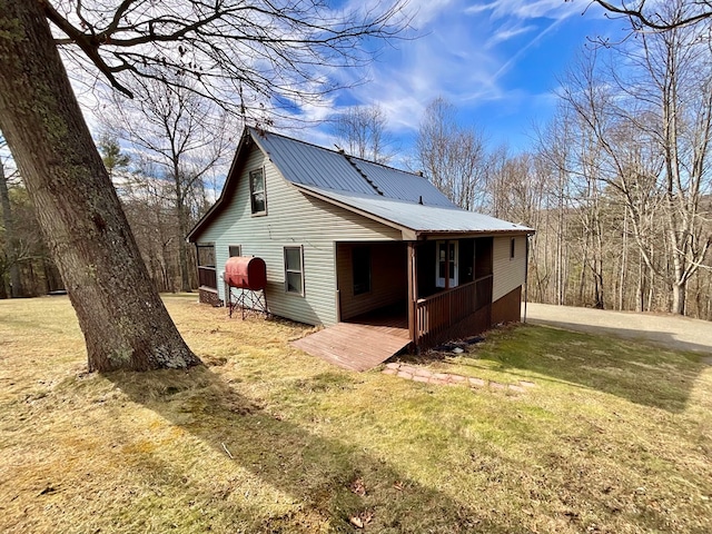 back of house featuring a yard and metal roof