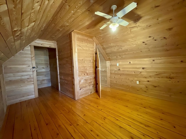 additional living space featuring vaulted ceiling, wooden walls, wooden ceiling, and wood-type flooring