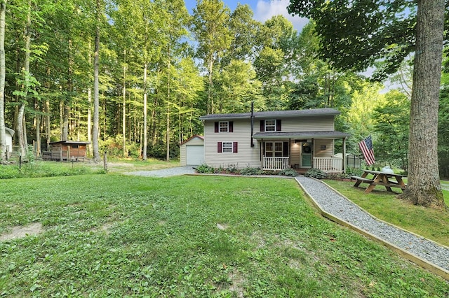 back of house with covered porch, a yard, an outbuilding, and a garage