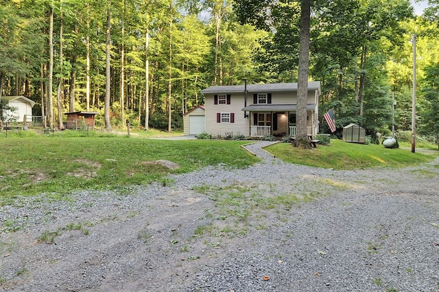 view of front facade featuring a porch, a garage, a front lawn, and a storage unit