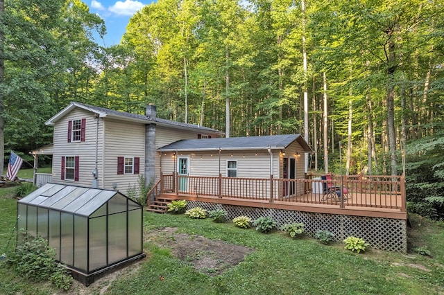 back of property featuring an outbuilding, a wooden deck, and a yard