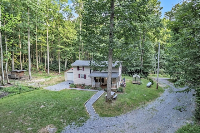 view of front of home featuring a front yard, an outdoor structure, and a porch