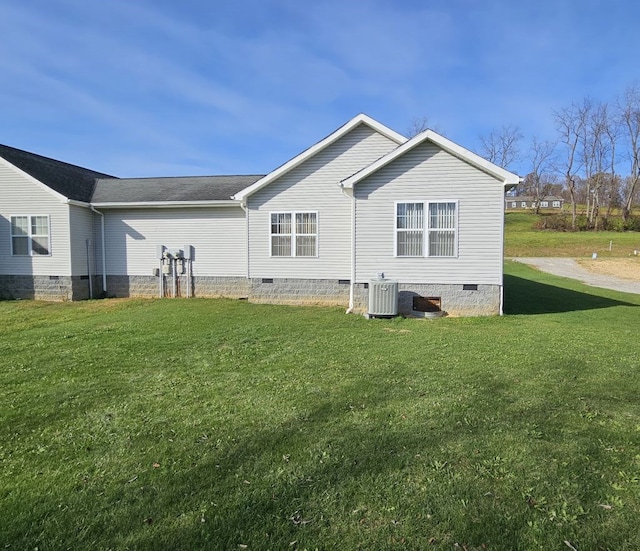 rear view of property with crawl space, central air condition unit, and a lawn