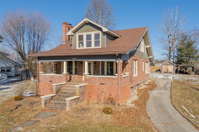 view of front facade with a porch and a storage shed