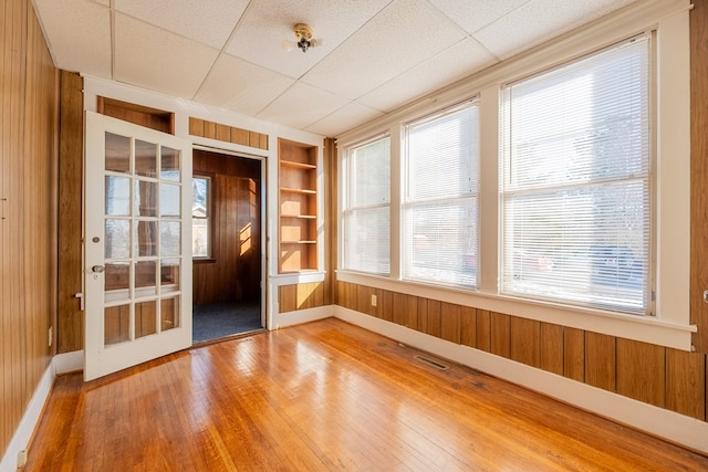 unfurnished sunroom with a drop ceiling