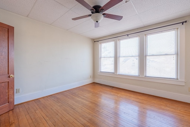 spare room with light wood-type flooring and a drop ceiling